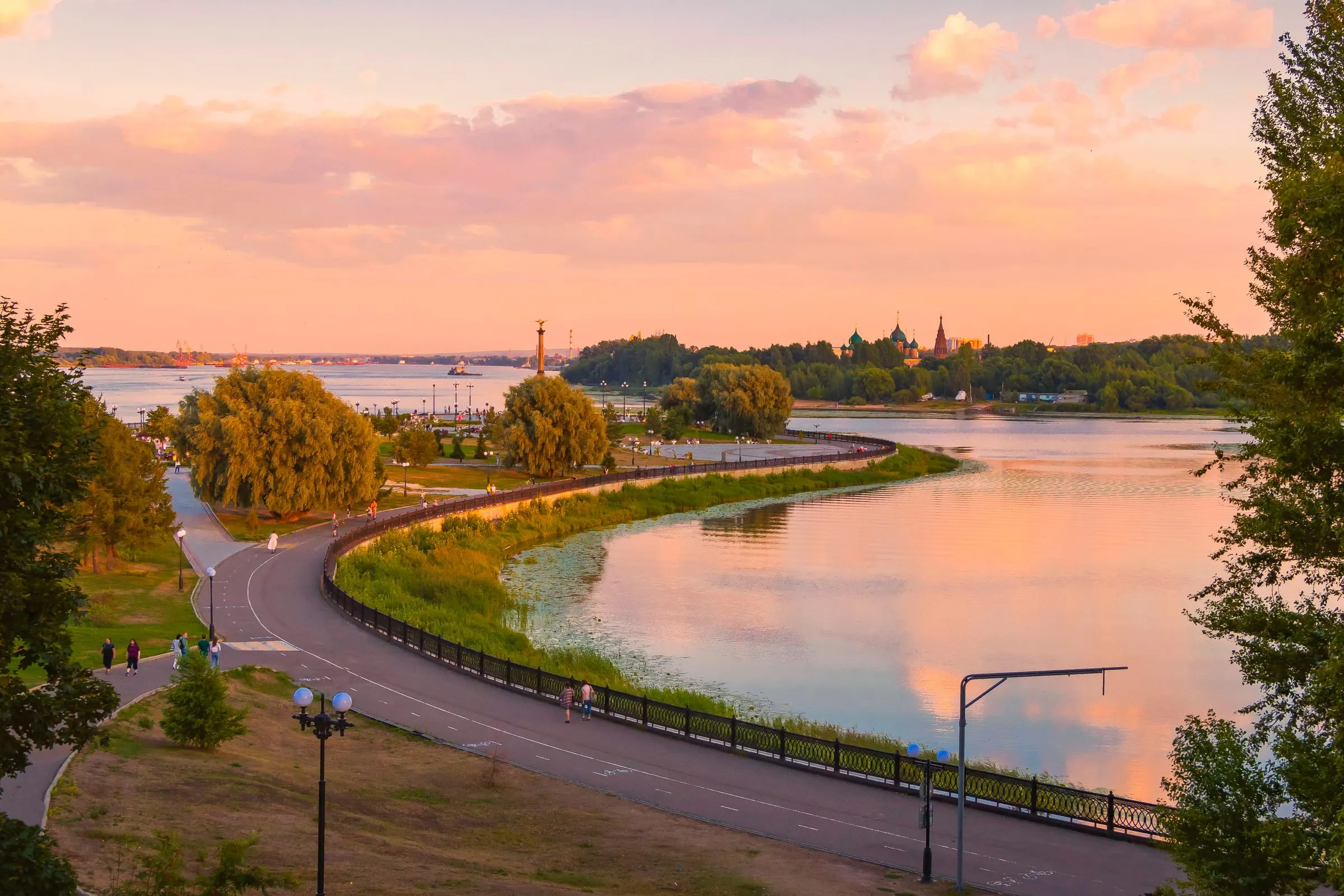 Abendlicht über der Strelka in Jaroslawl, wo die Kotorosl in die Wolga mündet, mit Kirchtürmen am Horizont